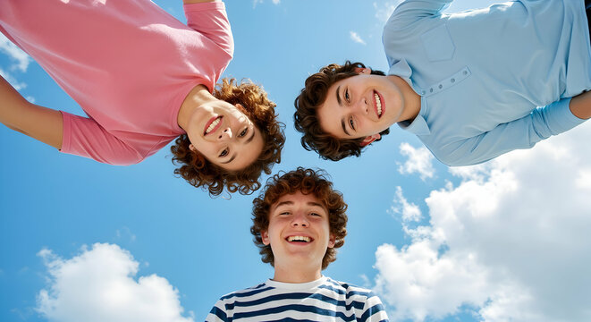 Happy teenage boys friends looking up at sky summer friendship joy