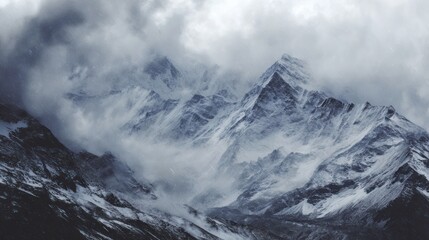 Obraz premium Majestic Snow-Capped Mountains Surrounded by Dramatic Clouds