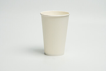 A single, tall, cylindrical cup with a handle and flared rim, likely made of ceramic or plastic, on...
