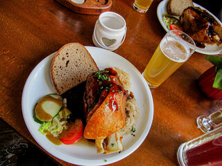 Famous German knuckle with sauerkraut, salad and bread and a glass of German beer on a table in a restaurant