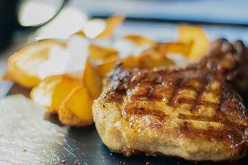 Juicy, mouthwatering steak on a platter served with country-style potatoes