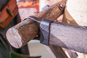 Close-up of weathered wooden object, textured and aged, with metal brackets joining pieces Shadows...