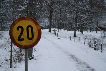 speed sign by snow covered road