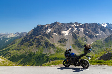 Motorcycle parked on mountain road enjoying breathtaking Alps landscape