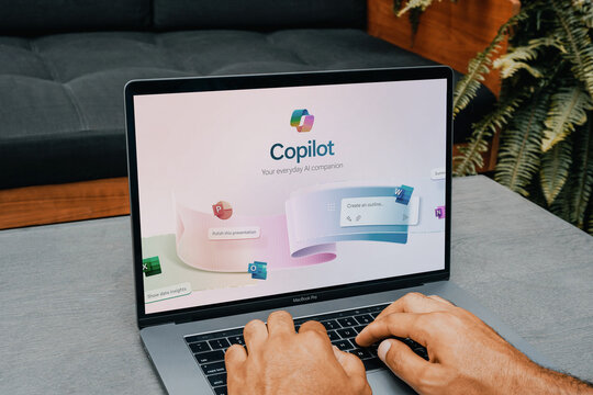 Office worker using copilot, microsoft's new ai companion, on a macbook pro