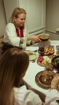 Delicious dishes are served as a family enjoys their time together in a warm kitchen setting. consumption of Ukrainian kuti at Christmas