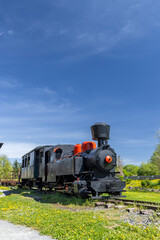 Naklejka premium Black steam train with orange details parked on a sunny day in Slovakia