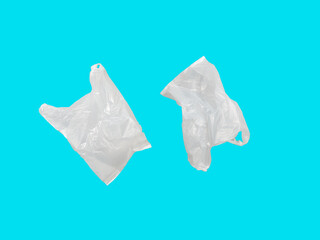 Obraz premium The image shows two transparent plastic bags floating against a bright blue background. Both bags appear crumpled and semi-transparent