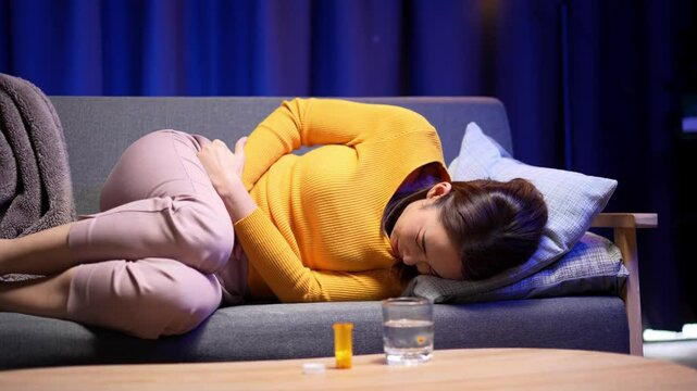 Video 4K Resolution of Asian woman with hands squeezing belly having painful stomach ache or period cramps, feeling abdominal menstrual pain, Abdominal pain, gastritis, diarrhea, indigestion