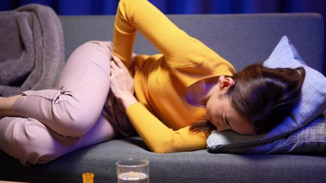 Video 4K Resolution of Asian woman with hands squeezing belly having painful stomach ache or period cramps, feeling abdominal menstrual pain, Abdominal pain, gastritis, diarrhea, indigestion