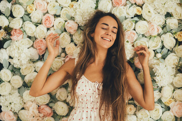 Beautiful woman with long hair in a flower decorated room.