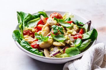 Butter bean salad with tomato, basil and avocado dressing.