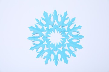 One paper snowflake on white background, top view