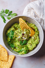 Avocado guacamole spread with nacho corn chips.