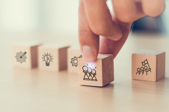 Business strategy concept. Wooden blocks with icon representing business strategies elements; teamwork, partnership, innovation and technology, target and growth. Business goal acheivement.