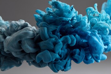 Colorful swirls of blue and teal ink mixing in water create a mesmerizing abstract design