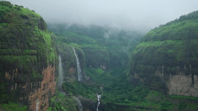 4K shot of waterfall falling from a mountain during the monsoon season as seen from Savlya Ghat in Maharashtra, India. Waterfall from the mountain during the monsoon in Sahyadri mountain ranges.