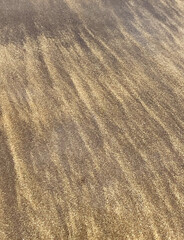 Volcanic sand pattern wavy texture on the beach of  El Medano, Tenerife, Canary Islands, Spain. Abstract nature background for design.