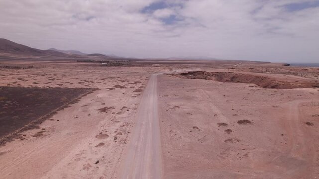 Drone Flyover of Red Desert Terrain and Coastal Road Near El Cotillo