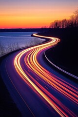 Highway light trails at sunset scenic view of winding road near lake with vibrant colors and motion blur long exposure photography