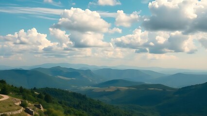 Naklejka premium Serene mountain vista showcasing a breathtaking panoramic view of rolling hills under a vibrant blue sky adorned with fluffy white clouds ideal for travel nature posters and scenic desktop backgrounds