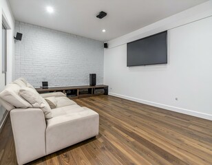 Modern home theater room with beige sofa, large screen TV, white brick wall, and wood floor. Perfect for relaxation and entertainment.