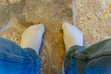 man feet wearing with white shocks kept at stone at day