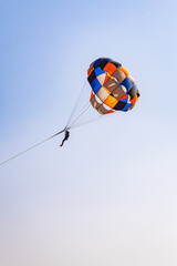 parasailing adventure activity at desert with bright blue sky background at day from flat angle