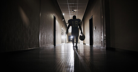 Back, football and light with man in corridor for sports competition, stadium match and game. Fitness, pro league player and athlete with person in tunnel for training, tournament and contest © peopleimages.com