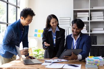 Group of Asian business people looking at digital tablet during meeting. Business people having a meeting in the office, brainstorming and working together on a project using a digital tablet.