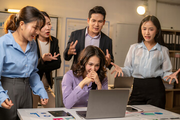 A group of people are gathered around a laptop computer