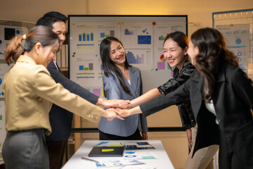A group of women are standing around a table with a white board behind them