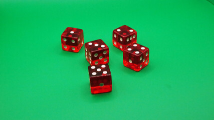 Red dice for board games on a green background.