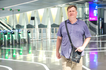 Man Standing on Subway Platform with Turnstiles in the Background Urban Scene.