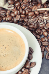 Coffee in cup and roasted dark coffee beans