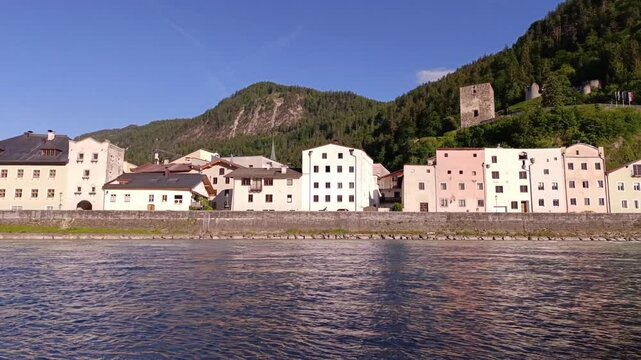 Beautiful riverside view of historic buildings and mountains in a quaint village during bright daylight