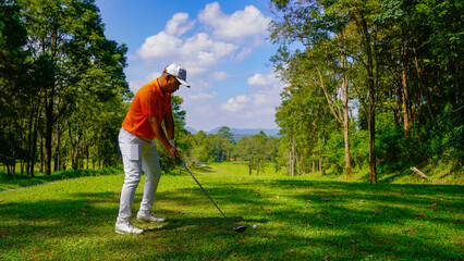 Golfer playing golf in the evening golf course, on sun set evening time.