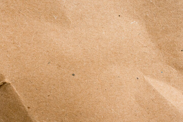 Close up of brown textured paper surface with subtle creases