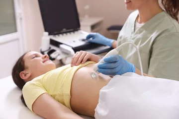 Fotobehang Sonographer conducting girl's abdominal ultrasound examination in clinic, closeup © New Africa