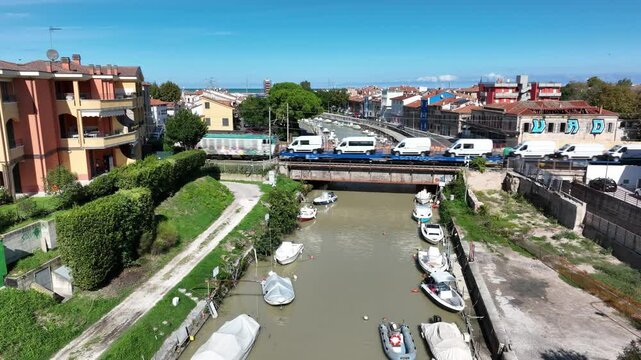 Drone footage of a train carrying cars across a bridge over the river flowing into the Adriatic Sea in Senigallia, Italy.