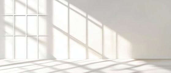 Obraz premium Sunlight streams through a window, casting geometric shadows on a clean, empty white room.