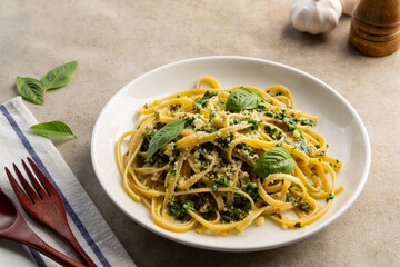 fettuccine pasta with kale walnut pesto sauce in white plate.