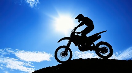 Silhouette of a Motocross Rider Performing a Jump Against a Bright Blue Sky with Sunlight Radiating and Clouds in the Background, Capturing Action and Adventure