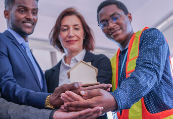 business engineering teamwork doing hands stacked and holding house mode together,concept real...