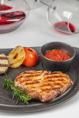 grilled pork steak with herbs and tomato sauce. Close up. top view