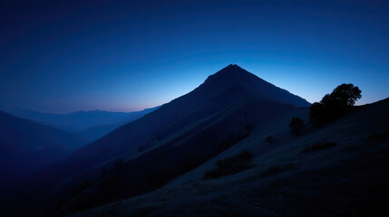 Mountain silhouette under twilight sky, serene blue tones blending into dusk, nature's quiet grandeur