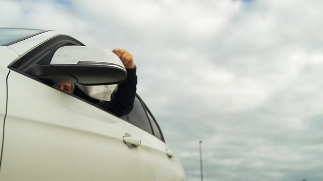 Man throwing garbage out of a car window into the street and polluting the environment.