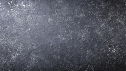Obraz premium A textured, dark gray surface with subtle light speckles. Variations in tone create a mottled effect