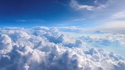 Fototapeta premium Wonderful view from the airplane window flying above the clouds cumulus clouds with blue sky in sunny day and soft sunlight in the afternoon nature background, creative banner, copyspace image