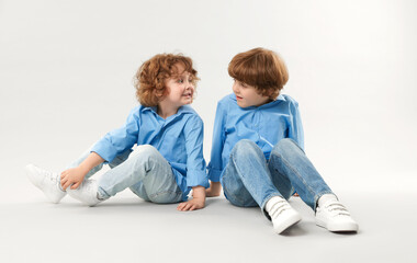Cute little brothers together on light background